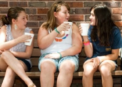 Three girls sit on a bench and enjoy soda from Guerin's Pharmacy in Summerville, SC